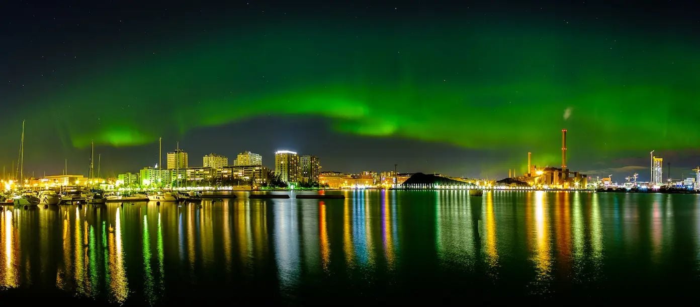 Aerial view of Finland’s coast with Aurora Borealis for guide on hiring in Finland