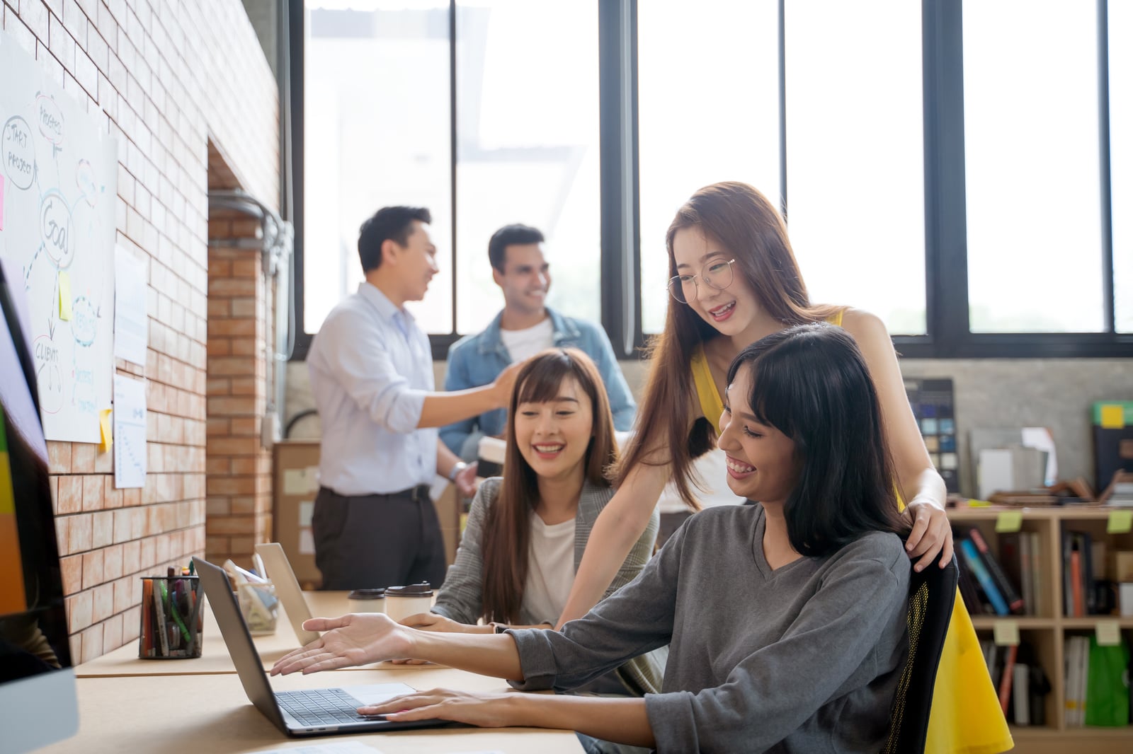 Young professional women working on a laptop together in an office